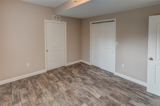 unfurnished bedroom featuring hardwood / wood-style flooring and a closet