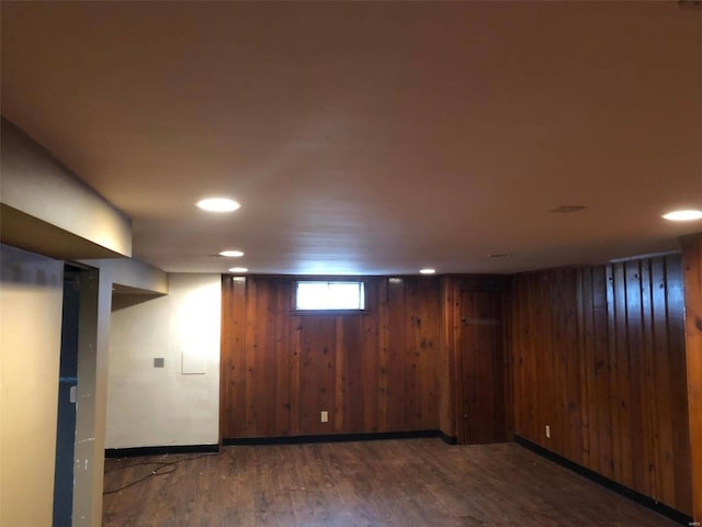 basement with wooden walls and dark hardwood / wood-style flooring