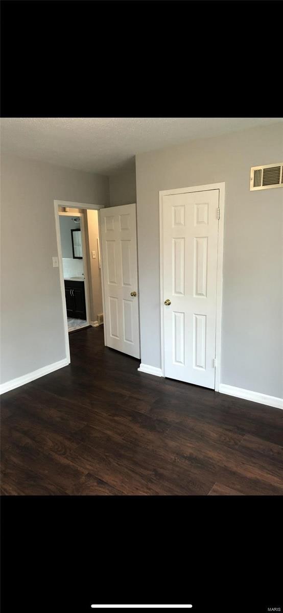 unfurnished bedroom featuring dark hardwood / wood-style flooring