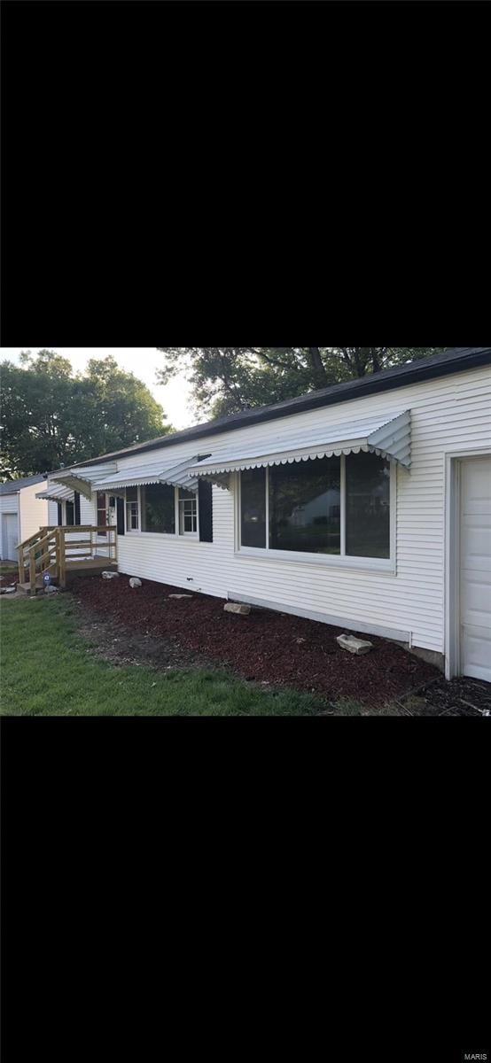 view of side of home with a yard