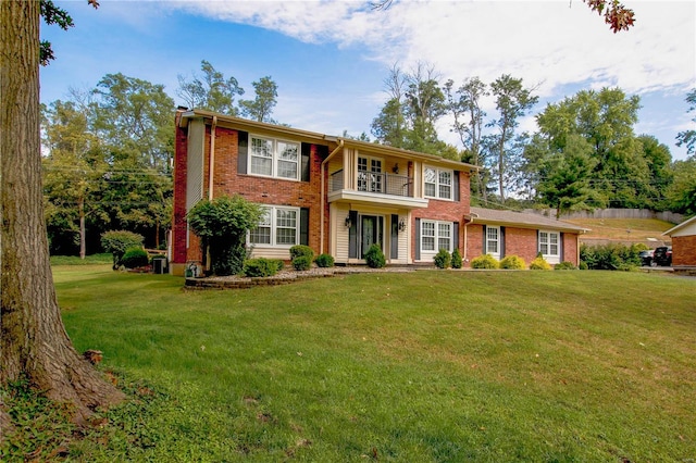 view of front of house with a front yard and a balcony