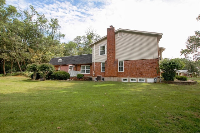 rear view of property with a lawn and central AC