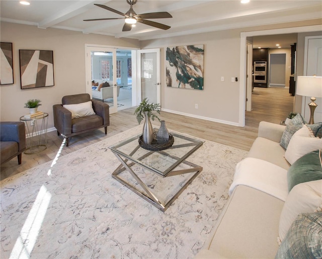 living room featuring beam ceiling, ceiling fan, light hardwood / wood-style flooring, and french doors