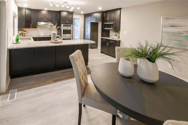 dining room featuring sink and light hardwood / wood-style flooring