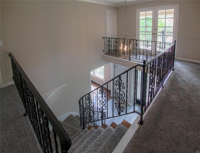 staircase with crown molding, french doors, and carpet floors