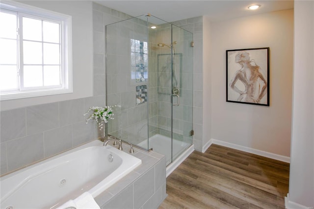 bathroom with hardwood / wood-style floors and shower with separate bathtub