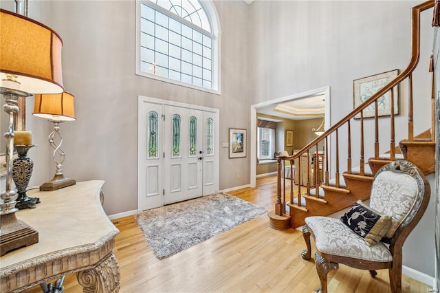 entryway with a towering ceiling and light hardwood / wood-style floors