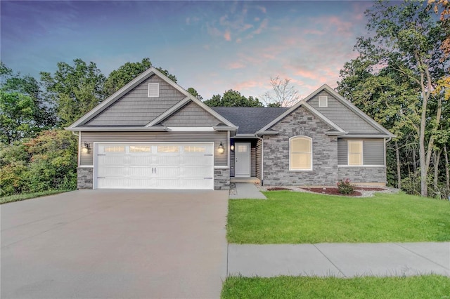 craftsman inspired home featuring a garage and a lawn