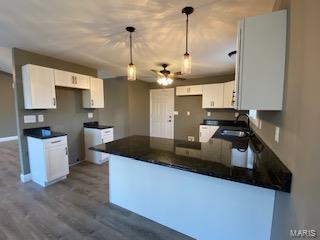 kitchen featuring ceiling fan, white cabinets, pendant lighting, kitchen peninsula, and dark hardwood / wood-style flooring