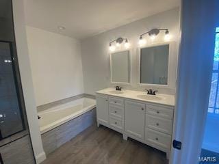 bathroom with hardwood / wood-style flooring, vanity, and a bathing tub