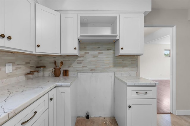 kitchen featuring backsplash, light hardwood / wood-style floors, and white cabinets