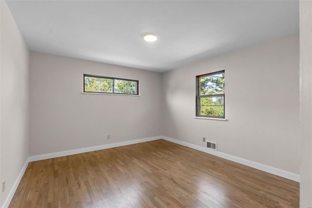 spare room featuring hardwood / wood-style flooring and a healthy amount of sunlight