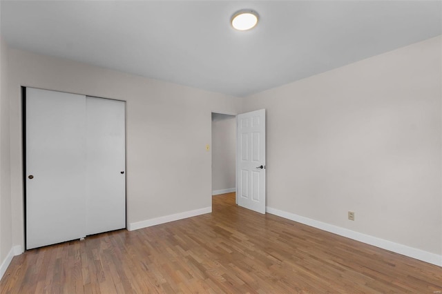 unfurnished bedroom featuring a closet and light wood-type flooring