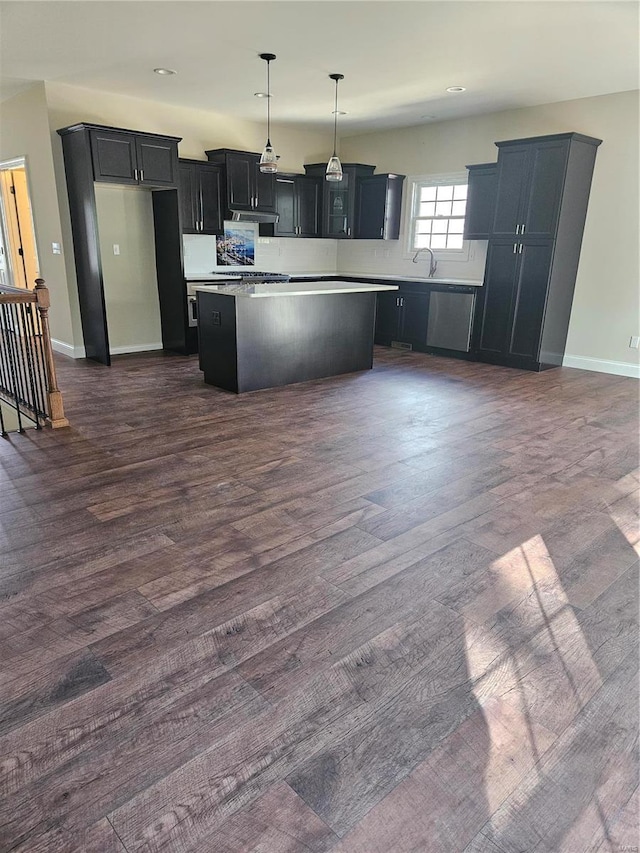 kitchen featuring pendant lighting, sink, dark wood-type flooring, and a center island