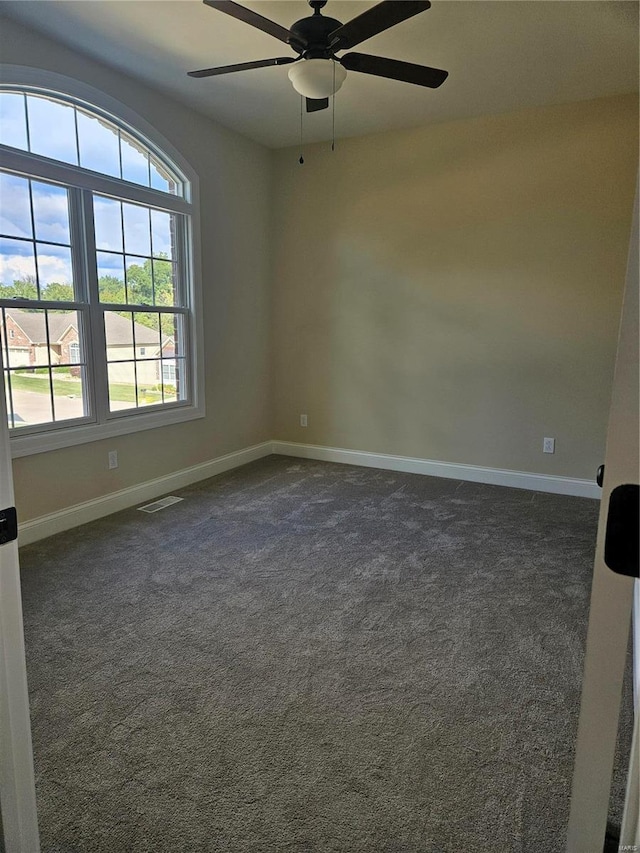 carpeted spare room featuring ceiling fan