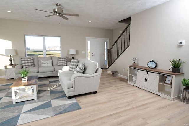 living room featuring ceiling fan and light hardwood / wood-style floors