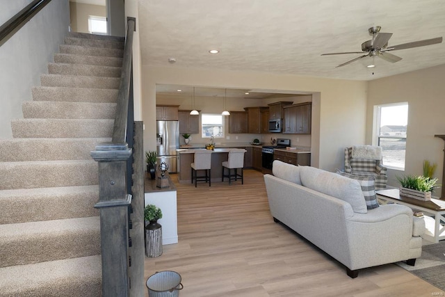 living room with ceiling fan and light hardwood / wood-style floors