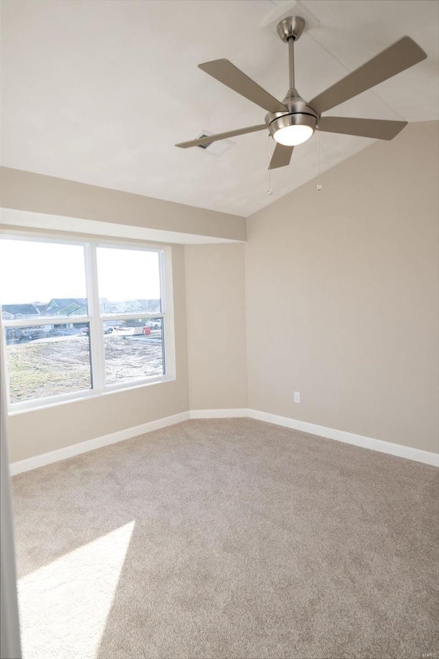 spare room with carpet flooring, vaulted ceiling, and ceiling fan