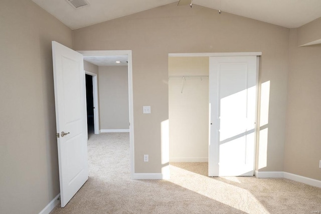 unfurnished bedroom featuring a closet, light colored carpet, and vaulted ceiling