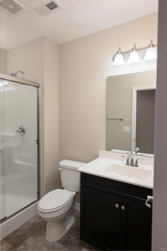 bathroom with vanity, a shower with shower door, and toilet