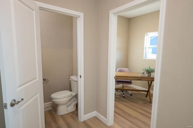 bathroom featuring hardwood / wood-style floors and toilet