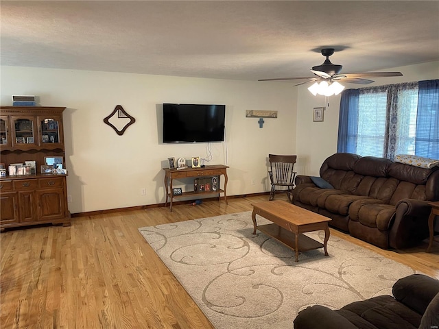 living room with light wood-type flooring, a textured ceiling, and ceiling fan