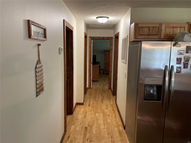 hallway featuring a textured ceiling and light hardwood / wood-style floors