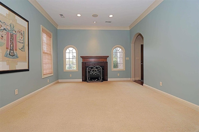 unfurnished living room featuring crown molding, light carpet, and a wealth of natural light