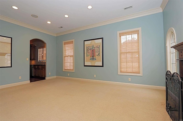 unfurnished room with ornamental molding and light colored carpet