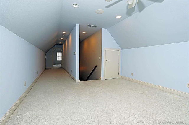 additional living space with lofted ceiling, light carpet, and ceiling fan