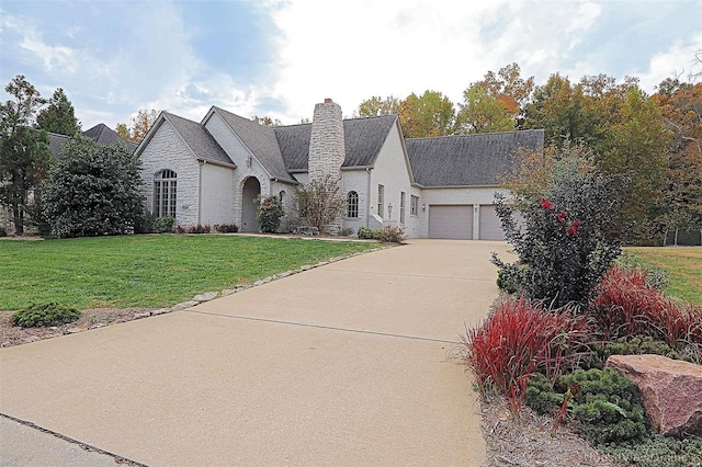 french country home with a front lawn and a garage