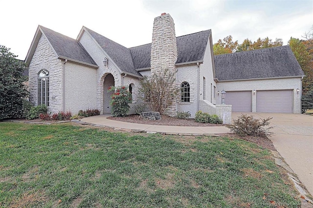 french country inspired facade with a front yard and a garage