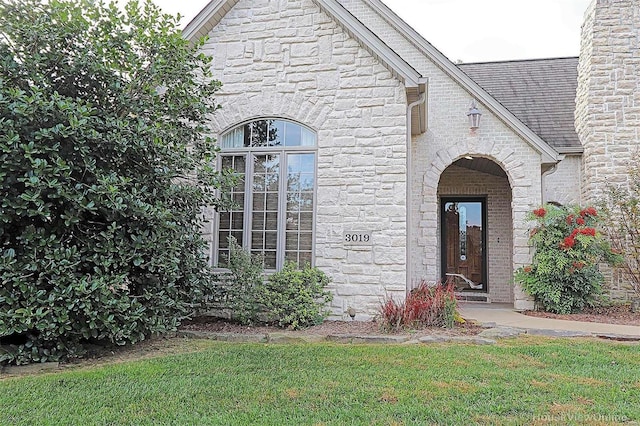 entrance to property featuring a lawn