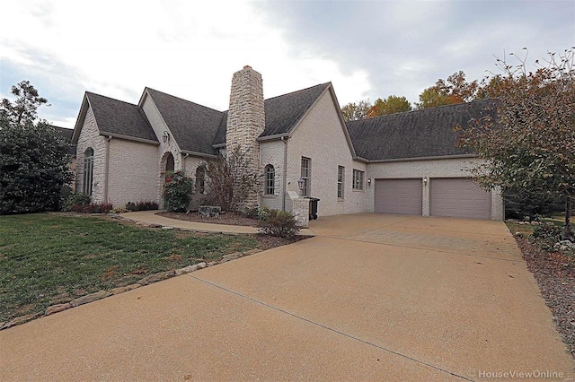 french country style house featuring a front lawn and a garage