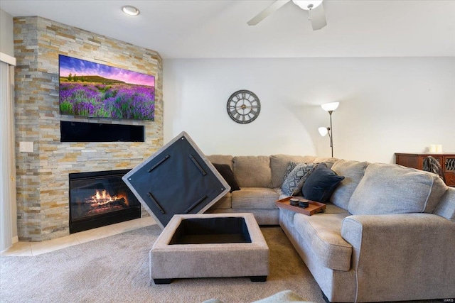 living room with ceiling fan and a stone fireplace