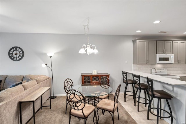 tiled dining room with a chandelier