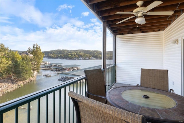 balcony featuring a water view and ceiling fan