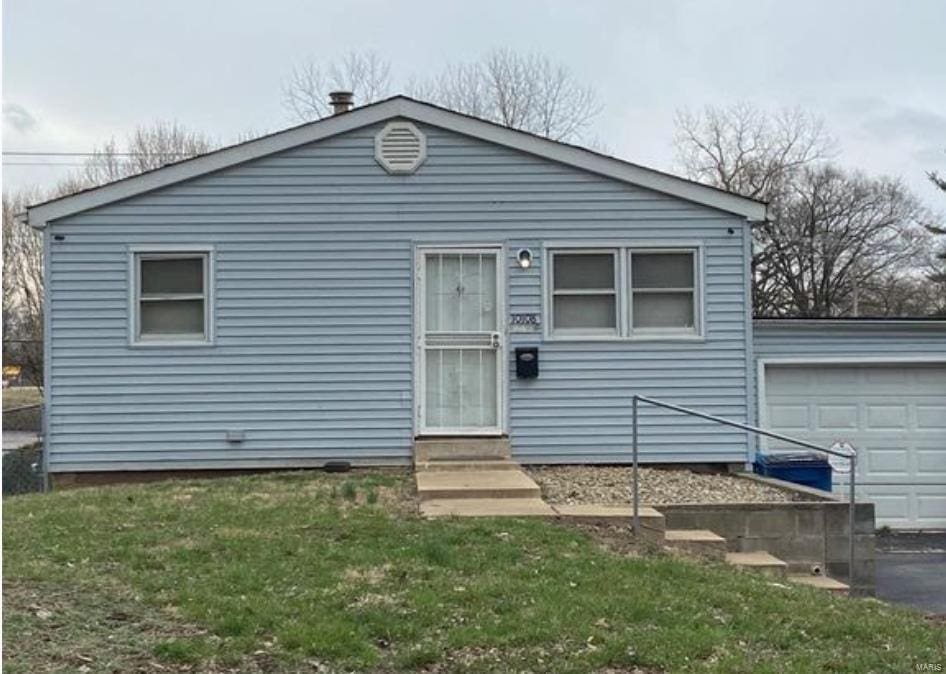 view of front of home featuring a front yard and a garage