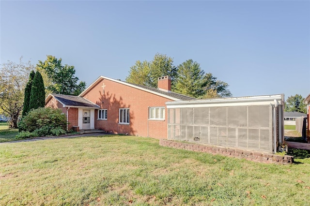 exterior space featuring a sunroom and a yard