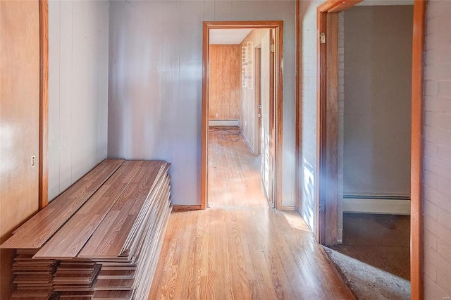 corridor with light wood-type flooring and baseboard heating