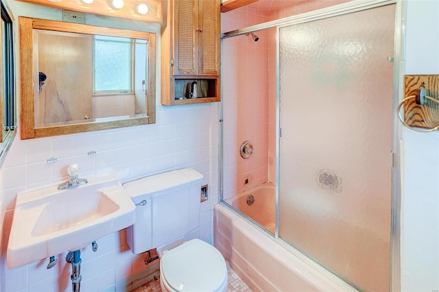 full bathroom with tile walls, backsplash, shower / bath combination with glass door, and toilet