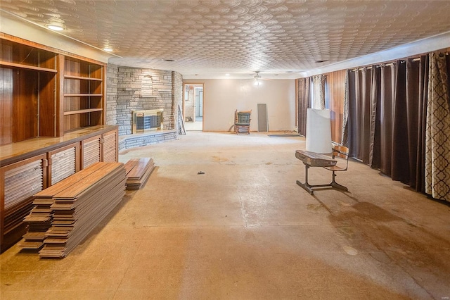 unfurnished living room featuring ceiling fan and a fireplace