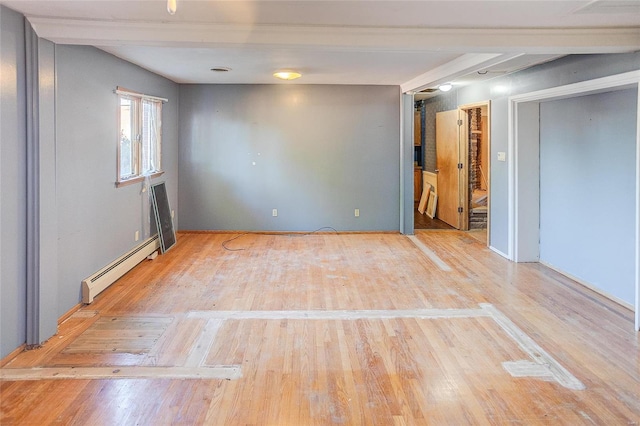 unfurnished room featuring hardwood / wood-style flooring and baseboard heating