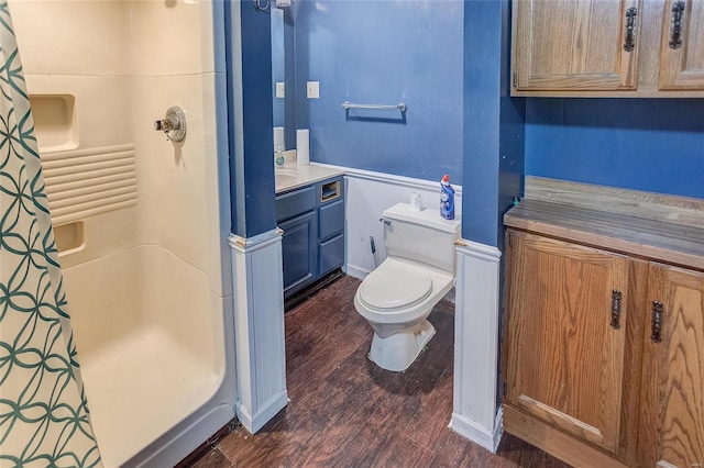 bathroom with wood-type flooring, toilet, vanity, and curtained shower