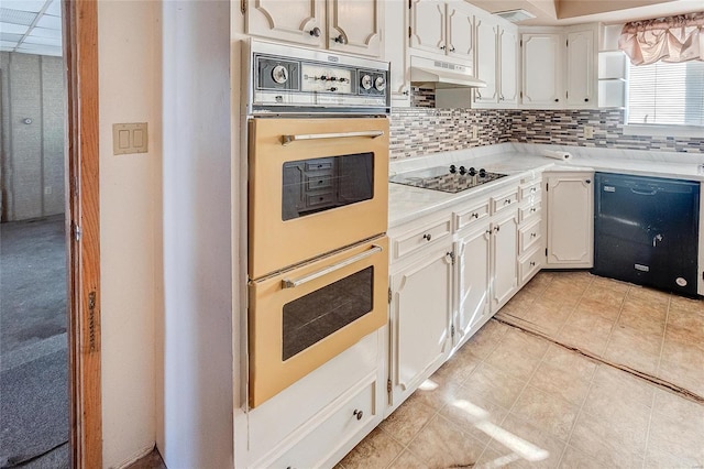 kitchen with black appliances, white cabinetry, light tile patterned floors, and backsplash