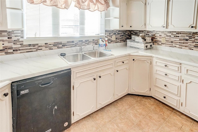 kitchen featuring black dishwasher, white cabinetry, sink, and tasteful backsplash