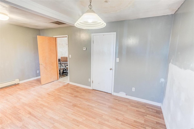 empty room featuring a notable chandelier, light hardwood / wood-style floors, and a baseboard heating unit