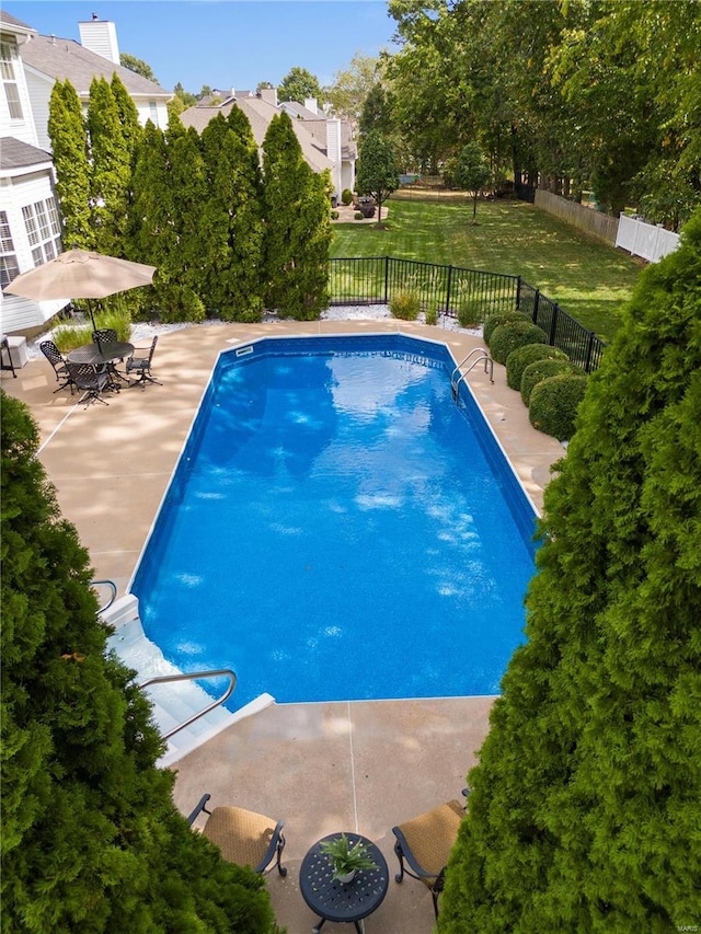 view of swimming pool with a patio area and a lawn