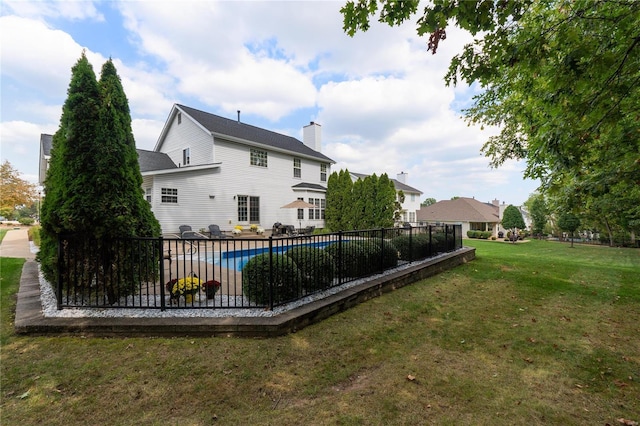 rear view of property with a covered pool and a lawn