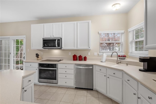 kitchen with sink, a wealth of natural light, white cabinets, and appliances with stainless steel finishes